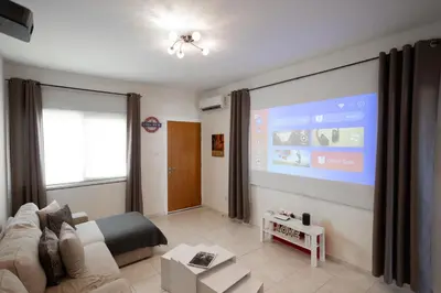 a living room with a couch and a large screen at Leah's Deluxe Villa in Tersephanou