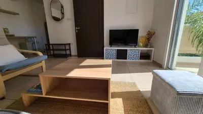 a living room with a couch and a tv at Mythical Sands resort - Hana in Paralimni