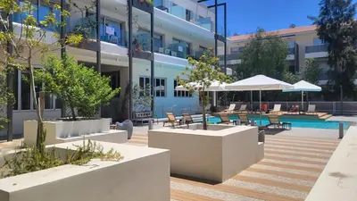 a building with a courtyard with a swimming pool at Mythical Sands resort - Hana in Paralimni