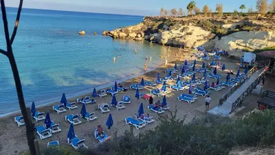 a group of chairs and umbrellas on a beach at Mythical Sands resort - Hana in Paralimni