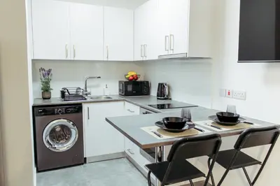 a kitchen with white cabinets and a washer and dryer at Cozy Studio Apt - Tourist Area Collection in Limassol