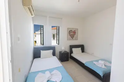 a bedroom with two beds and a window at Protaras Orestiada Villa OV14 in Protaras