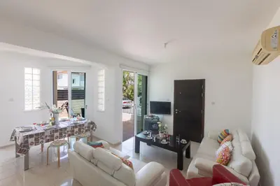 a living room with couches and a table and a television at Protaras Orestiada Villa OV14 in Protaras
