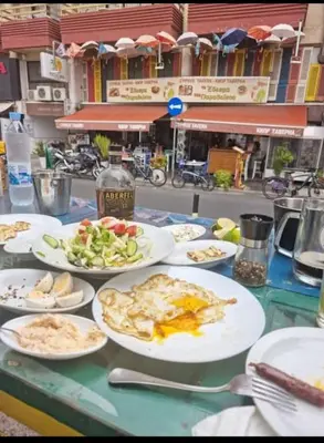 a table topped with plates of food on top at Petalmo City Apartments in Larnaka