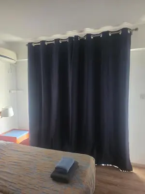 a black curtain in a room with a bed at Petalmo City Apartments in Larnaka