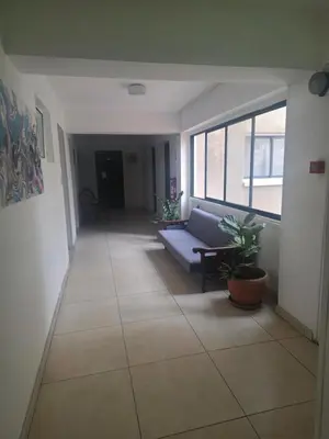 a living room with a couch and a large window at Petalmo City Apartments in Larnaka
