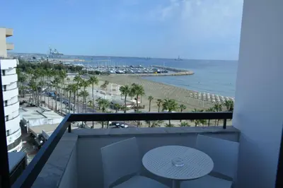 a balcony with a table and a view of the beach at Les Palmiers Sunorama Beach Apartments in Larnaka