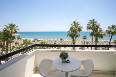 a balcony with a table and chairs and the beach at Les Palmiers Sunorama Beach Apartments in Larnaka