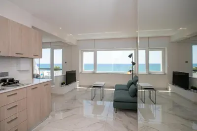 a kitchen and living room with a couch and a table at Les Palmiers Sunorama Beach Apartments in Larnaka