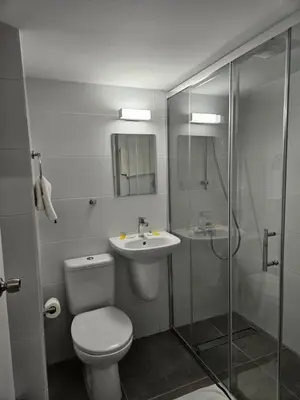 a bathroom with a toilet and a sink and a shower at Les Palmiers Sunorama Beach Apartments in Larnaka