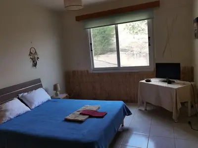 a bedroom with a bed and a table and a window at Lovely house apartment 2 bedrooms wiht nice view in Voroklini