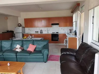 a living room with a blue couch and a kitchen at Lovely house apartment 2 bedrooms wiht nice view in Voroklini