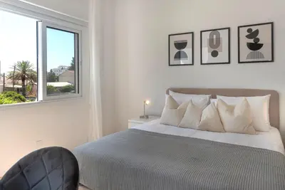 a white bedroom with a bed and a window at Phaedrus Living City Breeze Residences Urbanity in Larnaka