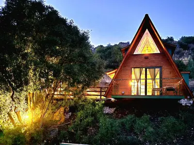 a house with a large window on the side of it at Warm Family Glamping Cabin with Kids Playground in Arakapas