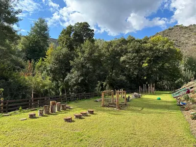 a park with wooden stumps in the grass at Warm Family Glamping Cabin with Kids Playground in Arakapas