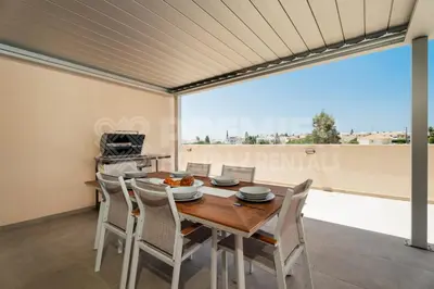 a dining room with a table and chairs and a large window at Apartment Anabelle in Paralimni