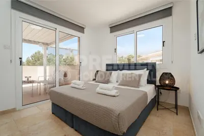 a bedroom with a large bed and large windows at Apartment Anabelle in Paralimni