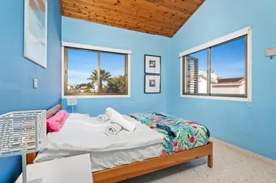 a blue bedroom with a bed and two windows at Ayia Napa Villa Jasmine Sirens Beach Dom na Cyprze in Ayia Napa
