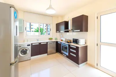 a kitchen with a washer and dryer in it at Villa Aurora - 100m from Pernera Beach in Protaras