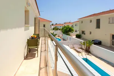 a balcony with a view of a swimming pool at Villa Aurora - 100m from Pernera Beach in Protaras