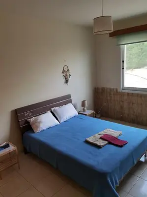 a bedroom with a blue bed with two towels on it at Lovely house apartment Oroklini in Voroklini