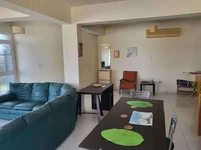 a living room with a blue couch and a table at Lovely house apartment Oroklini in Voroklini