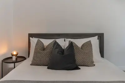 a bed with black and white pillows on it at Phaedrus Living City Breeze Residences Grace in Larnaka