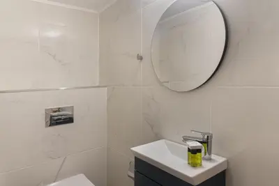 a white bathroom with a sink and a mirror at Phaedrus Living City Breeze Residences Grace in Larnaka