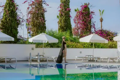 a woman walks by the pool at the resort at River Rock Hotel in Ayia Napa