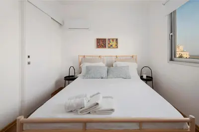 a bedroom with a white bed with two towels on it at Amazing Two Bedroom Apartment in Larnaka