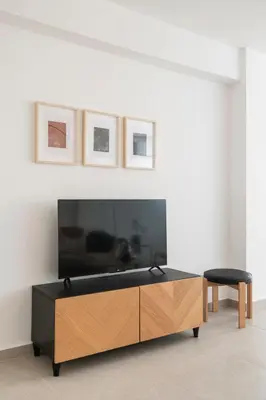a living room with a tv and a wooden cabinet at Amazing Two Bedroom Apartment in Larnaka