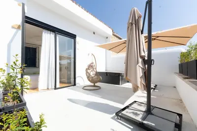 a patio with an umbrella and a chair at 1924 Gemini House Jacuzzi, Garden, Rooftop in Nicosia