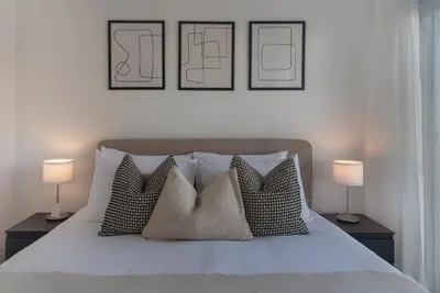 a bedroom with a bed with pillows and two lamps at Phaedrus Living City Breeze Residences Finesse in Larnaka