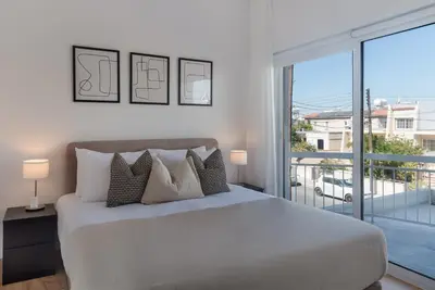 a bedroom with a large bed and a balcony at Phaedrus Living City Breeze Residences Finesse in Larnaka