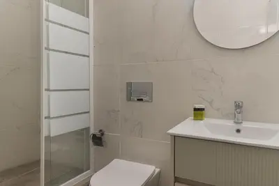 a bathroom with a toilet and a sink and a mirror at Phaedrus Living City Breeze Residences Finesse in Larnaka