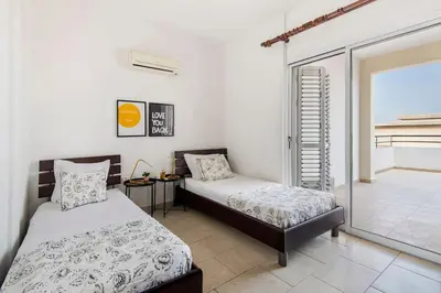 a bedroom with two beds and a balcony at City Center Top Floor Big Balcony 2BR Close to the Beach in Larnaka