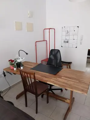 a wooden table with a chair and a desk at City Center Top Floor Big Balcony 2BR Close to the Beach in Larnaka