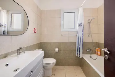 a bathroom with a sink toilet and a mirror at City Center Top Floor Big Balcony 2BR Close to the Beach in Larnaka