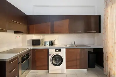 a kitchen with a washing machine and a microwave at City Center Top Floor Big Balcony 2BR Close to the Beach in Larnaka
