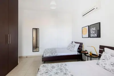 a white room with two beds and a mirror at City Center Top Floor Big Balcony 2BR Close to the Beach in Larnaka