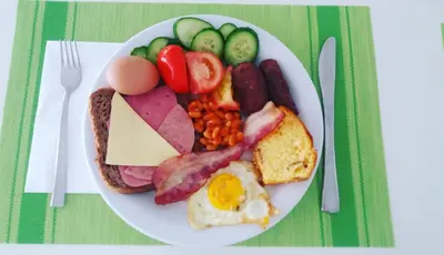 a plate of breakfast food with eggs sausage beans and vegetables at Sea CleoNapa Hotel in Ayia Napa