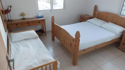 a bedroom with two beds and a desk and windows at ideal famille panoramic view lac salé in Larnaka