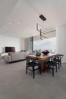 a dining room with a table and chairs and a couch at Protaras Eden Seaside Suite in Protaras