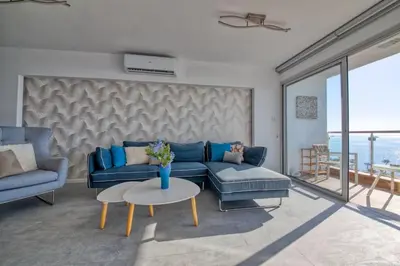 a living room with a blue couch and a table at Limassol Molos Hawaii Royal - Front-line 2 bedroom in Limassol