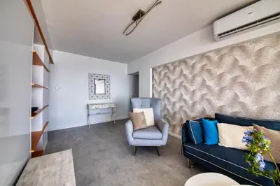 a living room with a blue couch and a chair at Limassol Molos Hawaii Royal - Front-line 2 bedroom in Limassol