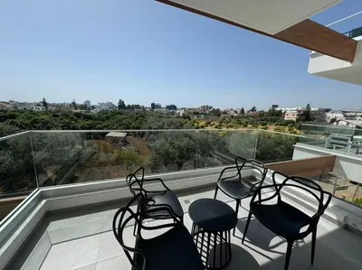 a balcony with three chairs and a view of the city at Limassol Beautiful Apartment in Limassol