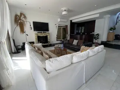 a living room with a white couch and a fireplace at Beachfront villa Meneou in Meneou