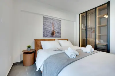 a bedroom with a large white bed with towels on it at Sea Front Luxury Apartment in Voroklini
