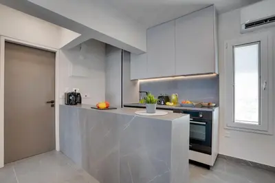 a kitchen with white cabinets and a counter at Sea Front Luxury Apartment in Voroklini