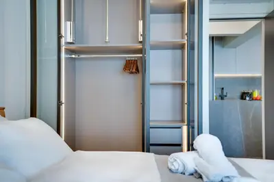 a bedroom with a bed and an open closet at Sea Front Luxury Apartment in Voroklini